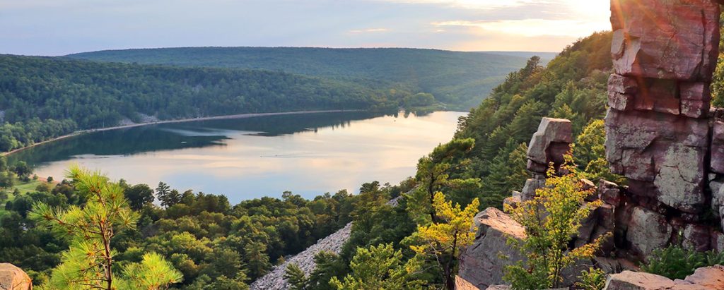 Devil's Lake shines beautifully under the midday sun as viewed from a rocky high altitude hiking trail.